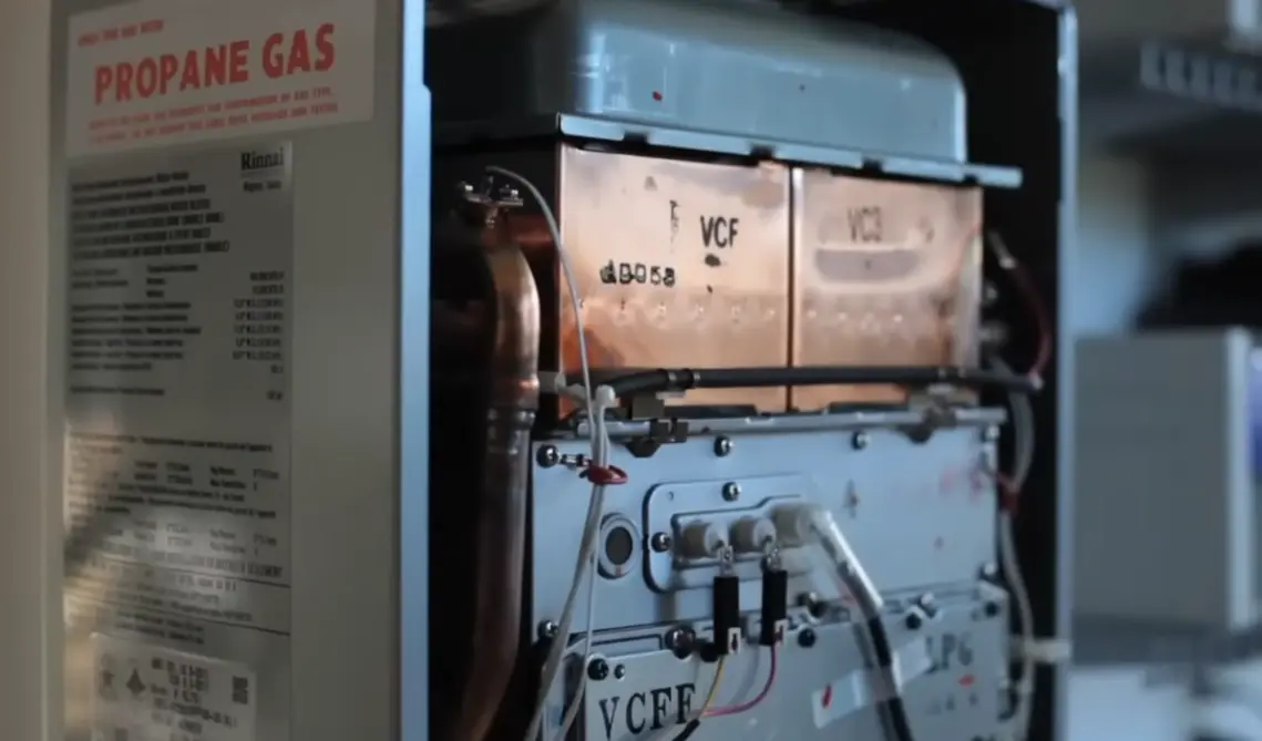 Old traditional storage tank water heater being replaced with tankless unit in Tustin CA home